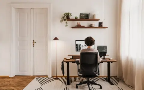 Un espace de travail épuré, avec une personne assise à son bureau, créant le bureau idéal.