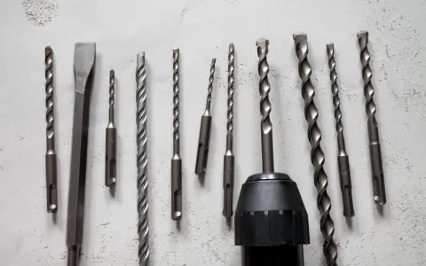 Variedad de tipos de mandriles para taladros, incluyendo brocas para concreto y un cincel, listos para cualquier trabajo.