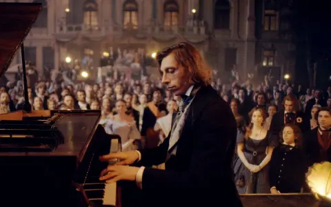 Młody Fryderyk Chopin gra na fortepianie przed zgromadzoną publicznością.