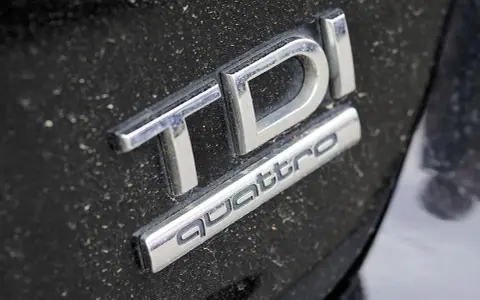 Emblemat TDI Quattro na zakurzonym czarnym lakierze. Zastanawiasz się, audi q5 2.0 tdi ile oleju?