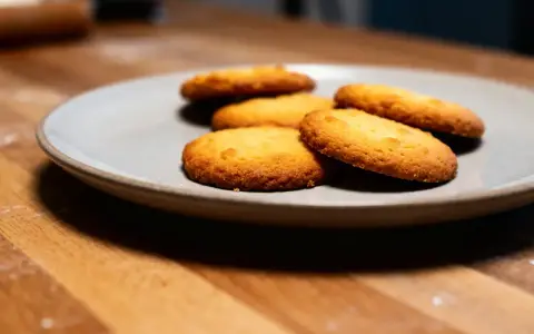 Assiette de sablés fondants au beurre, dorés et appétissants, sur un fond en bois.