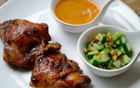 Krispigt, glansigt sticky chicken serveras med en krämig sås och en fräsch gurksallad.