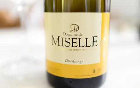 Butelka wina Domaine de Miselle, z wyraźnym napisem "Chardonnay". Idealne na letnie wieczory.