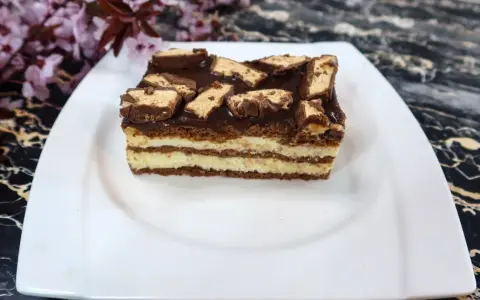 Sernik Milky Way z warstwami kremu i czekolady, ozdobiony kawałkami batoników.