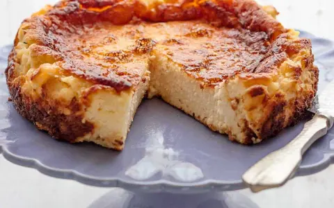 Tarta de queso La Viña, dorada y cremosa, servida en un plato morado.