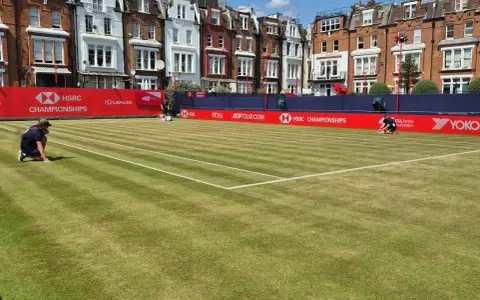 Jugadores preparan la cancha de césped para el torneo de Queen's Club.