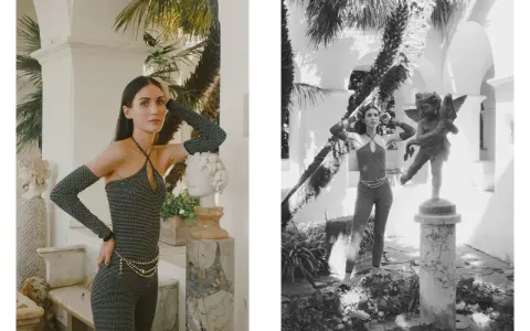 Modella con tuta scintillante e guanti lunghi, ispirata ai coco chanel abiti iconici, posa accanto a statue classiche in un giardino lussureggiante.