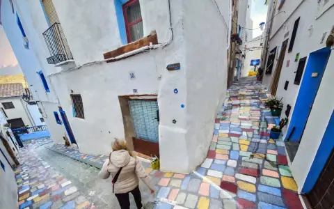 Callejuela de **Chelva pueblo azul**, con escalones de colores vibrantes y casas blancas adornadas con detalles azules.