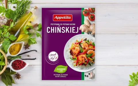 Opakowanie przyprawy do dań kuchni chińskiej Appetita. Obok świeże zioła, czosnek, imbir, pomidorki i składniki, jakie przyprawy do chińszczyzny.
