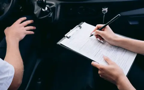 Kobieta wypełnia formularz podczas rejestracji samochodu przez dealera.