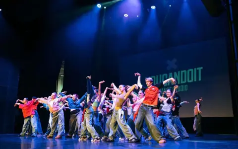 Tancerze na scenie, w ruchu, jakby tworzyli choreografię na żywo. To właśnie improwizacja co to – spontaniczność i kreatywność w tańcu.