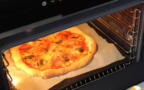 Une pizza maison dorée et appétissante cuit dans un four, prête à être dégustée. Une parfaite recette pizza au four.