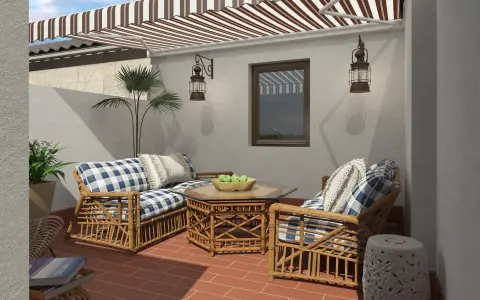 Ideas para decorar patios pequeños con poco dinero: muebles de ratán, cojines a cuadros y plantas crean un oasis acogedor.