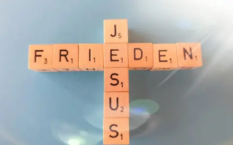 Holzbuchstaben bilden ein Kreuz mit den Wörtern "FRIEDEN" und "JESUS". Wie in Jesaja 43,2 versprochen, bringt Jesus Frieden.