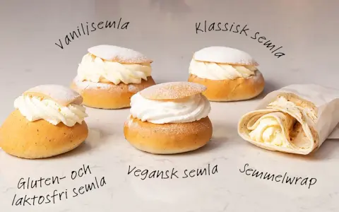 Fem olika semlor och en semmelwrap på ett marmorbord. Perfekt för semlor dagen!