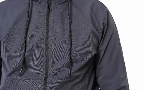 Szara kurtka softshell z zamkiem i sznurkami. Dowiedz się, jak prać softshell, by zachował swoje właściwości.