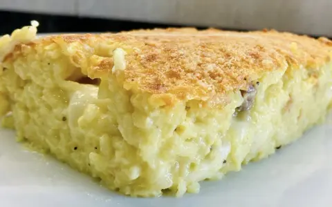 Una fetta di timballo di riso dorato e filante, con un ripieno cremoso e invitante.
