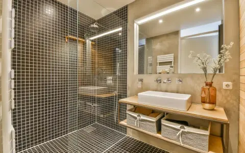 A modern bathroom with a walk-in tiled shower. Learn how to clean a walk-in tiled shower with this stylish setup.