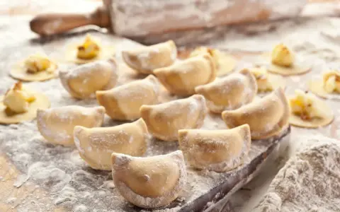 Gotowe do lepienia pierogi, posypane mąką. Zastanawiasz się, jaka mąka na pierogi będzie najlepsza? Ta wygląda idealnie!