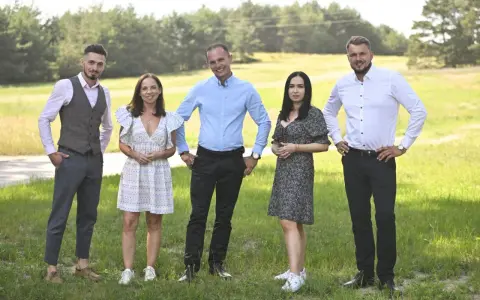 Uczestnicy programu "Rolnik szuka żony 10" pozują na tle zielonej łąki.