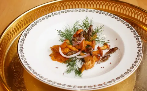En tallrik med kantareller, lökringar och dill. Ett spännande kantareller recept med en oväntad twist.