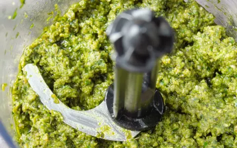 Zielone, świeże pesto w malakserze, gotowe do użycia. Tak właśnie wygląda proces, jak zrobić pesto.