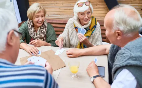 Seniorzy grają w karty, ćwicząc umysł i poprawiając pamięć.