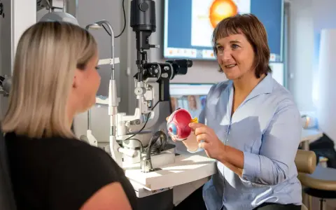 Augenarzt erklärt Modellauge. Mögliche Behandlung: Augen lasern. Krankschreibung wird besprochen.