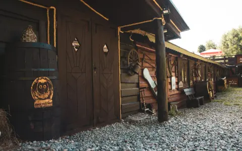 Drewniana chata wuja Toma z beczką i ozdobami.