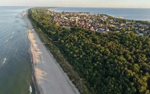 Piękna plaża i las, idealne miejsce, gdzie na majówkę. Widok z lotu ptaka na nadmorską miejscowość.