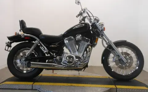 Czarny motocykl Suzuki Intruder 1400 z chromowanymi elementami, siedzeniem pasażera i bagażnikiem.