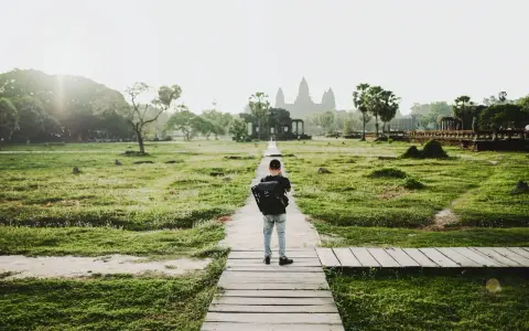 Chłopiec z plecakiem idzie ścieżką do Angkor Wat, jednego z cudów największego kontynentu na ziemi.
