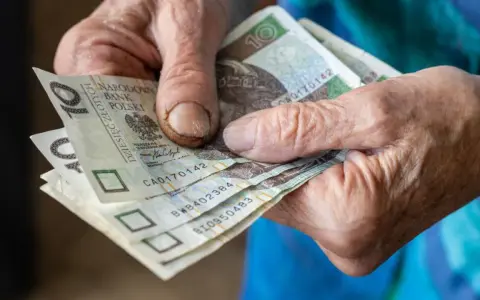 Dłonie seniora trzymają banknoty 10 zł. Kto może liczyć na 500 plus dla seniora?