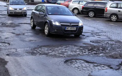 Samochody jadą po dziurawej drodze. Czy warto wykupić ubezpieczenie Europa Ubezpieczenia opinie?