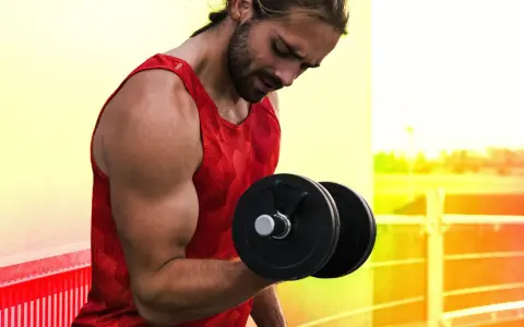 Homme musclé faisant un exercice pour muscler les bras avec un haltère.