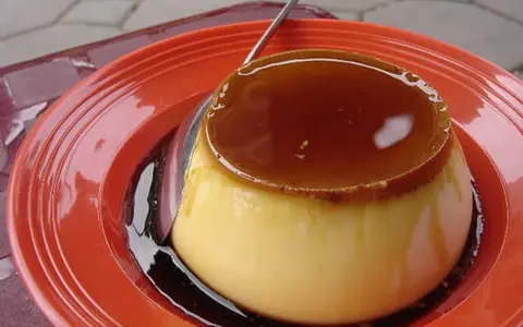 Un délicieux crème caramel, tout juste sorti du four, prêt à être dégusté. Sa texture onctueuse et son caramel doré invitent à la gourmandise.