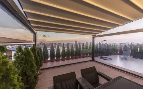 Terrazzo trasformato in stanza con chiusura trasparente, ideale per godersi il panorama.