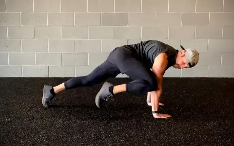 Un homme fait des mountain climbers pour son renforcement musculaire à la maison.
