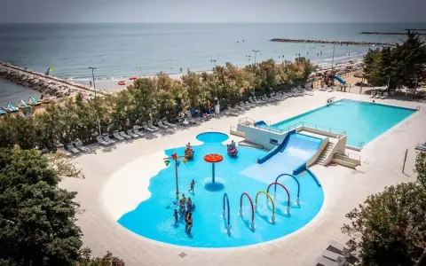 Rodzinna zabawa w wodnym świecie przy plaży w San Francesco Caorle: baseny, zjeżdżalnie i brodziki dla dzieci.