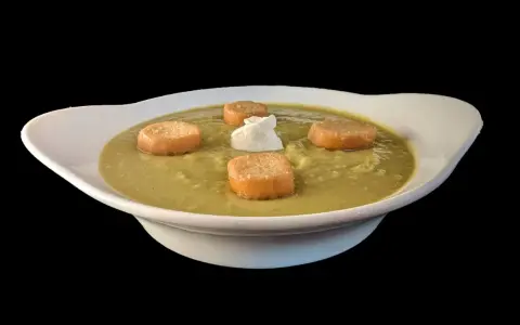 Soupe de pois cassés onctueuse, garnie de croûtons dorés et d'une touche de crème. Un délice réconfortant.