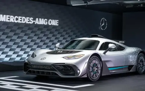 Silberner Mercedes-AMG ONE mit auffälligem Design und dem Schriftzug "MERCEDES-AMG ONE" im Hintergrund.