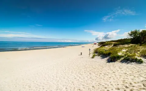 Piękna, piaszczysta plaża na Mierzei Wiślanej. Błękitne niebo i spokojne morze zapraszają do wypoczynku.
