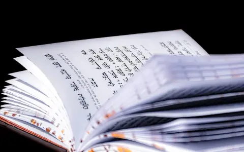 Otwarta księga z tekstem w języku hebrajskim, widoczny psalm 27 tekst.