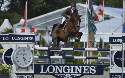 Le cavalier Cooper van de Heffinck et son cheval sautent un obstacle lors d'une compétition équestre.