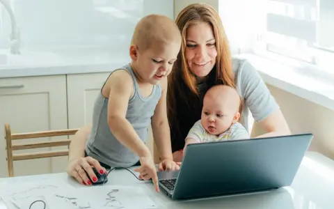 Mama z dwójką dzieci przy laptopie, starszak pokazuje coś na ekranie. To ich wspólny artystyczny projekt, może nawet z elementami art 188 kp.