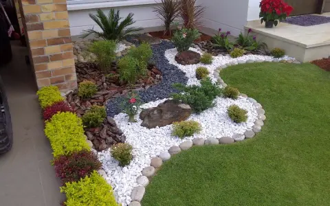 Piccoli giardini da sogno con ghiaia bianca, pietre scure, piante verdi e fiori rossi, un'oasi di pace.