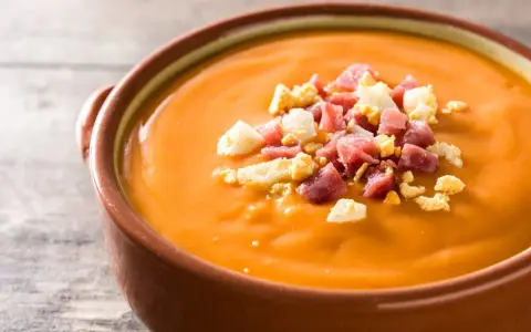 Un cuenco de salmorejo, la deliciosa comida típica de Córdoba, adornado con trocitos de huevo duro y jamón serrano.