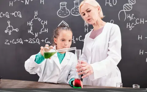 Nauczycielka chemii z pasją pokazuje uczennicy eksperyment. Ciekawe, ile zarabia nauczyciel chemii za taką pracę!