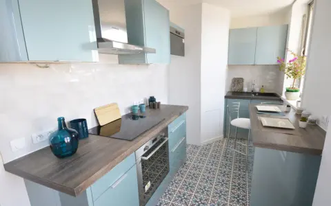 Cocina moderna y luminosa con armarios celestes y suelo hidráulico. Una opción económica para renovar cocina con poco dinero.