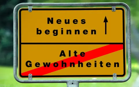 Gelbes Ortsschild: Oben "Neues beginnen" mit Pfeil nach oben, unten "Alte Gewohnheiten" durch roten Balken durchgestrichen. Das Symbol steht für die **passion bedeutung** neuer Wege.